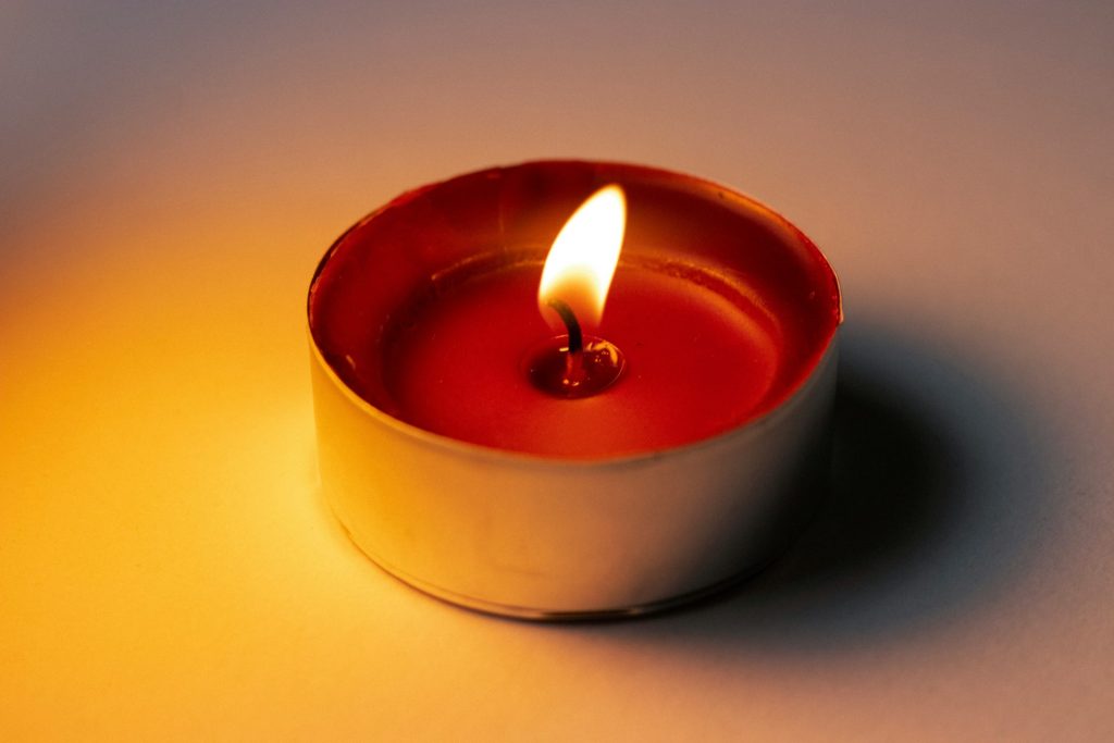A lit tea candle casting a warm glow